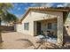 View of the back patio area with an exterior door, windows, and a small patio table with chairs at 897 E Cherry Hills Dr, Chandler, AZ 85249