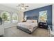 Spacious bedroom with large windows, accent wall, tufted headboard, and stylish decor at 897 E Cherry Hills Dr, Chandler, AZ 85249
