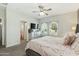 Bright main bedroom with a ceiling fan, arched windows, and a charming dresser and television at 897 E Cherry Hills Dr, Chandler, AZ 85249