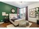 Stylish bedroom featuring a plush bed, emerald green wall, and contemporary decor elements at 9539 S 13Th Way, Phoenix, AZ 85042