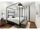 Serene bedroom with a four-poster bed, plush rug, and elegant black and white accents at 9539 S 13Th Way, Phoenix, AZ 85042
