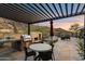 Outdoor kitchen with BBQ, fireplace, dining table, and desert landscaping at 9539 S 13Th Way, Phoenix, AZ 85042