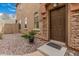 Charming entrance with a brown door, rock landscaping, and a welcoming doormat for a cozy curb appeal at 1350 S Greenfield Rd # 1225, Mesa, AZ 85206