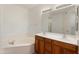 Bathroom featuring a double vanity, large mirror, and a corner soaking tub at 14000 N 94Th St # 3094, Scottsdale, AZ 85260