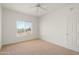 Well-lit bedroom featuring neutral carpet, a window, and a door at 14000 N 94Th St # 3094, Scottsdale, AZ 85260