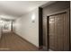 Condo hallway featuring neutral paint, carpet, and a door with decorative trim, creating a welcoming entrance at 14000 N 94Th St # 3094, Scottsdale, AZ 85260