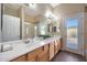 Bathroom with large mirror over double sinks and shower with a glass door to the backyard at 14442 W Lexington Ave, Goodyear, AZ 85395