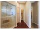 Bathroom featuring a glass shower, wood floors, and light wood cabinets at 14442 W Lexington Ave, Goodyear, AZ 85395