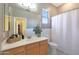 Bathroom featuring tile floors, single sink vanity, large mirror, and shower with white curtain at 14442 W Lexington Ave, Goodyear, AZ 85395