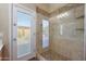 Modern bathroom featuring a glass-enclosed shower and access to the backyard at 14442 W Lexington Ave, Goodyear, AZ 85395