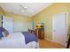 Bedroom with hardwood floors, ceiling fan, and a tv on top of a dresser at 14442 W Lexington Ave, Goodyear, AZ 85395