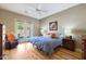 Bright bedroom featuring hardwood floors, ceiling fan, and french door to patio at 14442 W Lexington Ave, Goodyear, AZ 85395