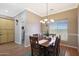 Dining room features wood table, chandelier lighting, and natural light, complemented by wood floors and neutral paint at 14442 W Lexington Ave, Goodyear, AZ 85395