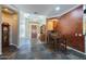 Inviting entryway with slate tile flooring, wood dining table, and custom paint leading to the living space at 14442 W Lexington Ave, Goodyear, AZ 85395