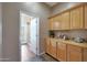 Hallway view of cabinets and doorway leading to bright bathroom with open door to backyard at 14442 W Lexington Ave, Goodyear, AZ 85395