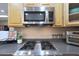 Close-up of a kitchen cooktop and stainless steel microwave, highlighting the gourmet features for cooking enthusiasts at 14442 W Lexington Ave, Goodyear, AZ 85395