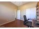 A well lit office room featuring a work desk, rolling chair, and closet with sliding doors at 14442 W Lexington Ave, Goodyear, AZ 85395