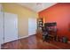 Home office showcasing a built in bookcase, closet, a desk, and wooden floors at 14442 W Lexington Ave, Goodyear, AZ 85395