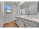 Bright bathroom showcasing a double vanity with white countertops and wood-style floors at 14761 W Tether Trl, Surprise, AZ 85387