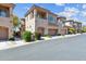 Inviting view of the townhome's facade, featuring a two-car garage, balcony, and desert landscaping in a gated community at 16420 N Thompson Peak Pkwy # 2091, Scottsdale, AZ 85260