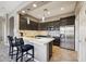 Modern kitchen with stainless steel appliances, dark cabinets, and a breakfast bar with pendant lighting at 16420 N Thompson Peak Pkwy # 2091, Scottsdale, AZ 85260