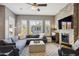 Elegant living room featuring a stone fireplace, plush seating, plantation shutters, and ample natural light at 16420 N Thompson Peak Pkwy # 2091, Scottsdale, AZ 85260