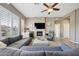 Comfortable living room featuring a stone fireplace, plush seating, plantation shutters, and ample natural light at 16420 N Thompson Peak Pkwy # 2091, Scottsdale, AZ 85260