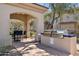 This outdoor kitchen features a stainless steel grill and adjacent seating for outdoor dining at 16420 N Thompson Peak Pkwy # 2091, Scottsdale, AZ 85260