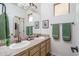 Bathroom featuring double sinks, tile countertops, and decorative towels at 1712 W Aloe Vera Dr, Phoenix, AZ 85085