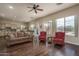 Spacious living room featuring hardwood floors, comfortable seating, and windows with views of the pool and desert landscape at 1712 W Aloe Vera Dr, Phoenix, AZ 85085