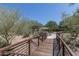 Outdoor walking bridge featuring desert landscape, a paved walking path, and shade provided by mature trees and native vegetation at 1712 W Aloe Vera Dr, Phoenix, AZ 85085