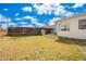 Spacious backyard featuring a well-kept lawn and a charming playhouse under a bright, partly cloudy sky at 1840 E Jarvis Ave, Mesa, AZ 85204