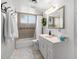 A well-lit bathroom featuring a shower-tub combination and a vanity sink with a large mirror at 1840 E Jarvis Ave, Mesa, AZ 85204