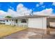 Charming single-story home featuring a welcoming porch, a well-maintained lawn, and an attached garage with an open carport at 1840 E Jarvis Ave, Mesa, AZ 85204