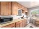 Traditional kitchen with wooden cabinets, tile floors, and a stainless steel microwave at 1840 E Jarvis Ave, Mesa, AZ 85204