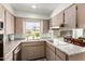 Well-lit kitchen with stainless appliances, tile backsplash, and a view of the backyard at 1840 E Jarvis Ave, Mesa, AZ 85204