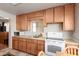 Functional kitchen featuring wooden cabinets, white appliances, and a window over the sink at 1840 E Jarvis Ave, Mesa, AZ 85204