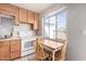 A well-lit kitchen featuring wood cabinets, white appliances, and a cozy dining nook at 1840 E Jarvis Ave, Mesa, AZ 85204