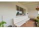 A cozy front porch seating area featuring a white bench and potted plants, perfect for relaxing and enjoying the outdoors at 1840 E Jarvis Ave, Mesa, AZ 85204