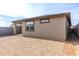 Exterior view of house backyard with a window, covered patio, and block fence, creating a secluded retreat at 1971 S 241St Dr, Buckeye, AZ 85326