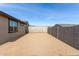 View of backyard featuring the home's exterior, with block fence, window, and ample space for outdoor activities at 1971 S 241St Dr, Buckeye, AZ 85326