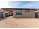 View of the house backyard with a covered patio, window, and block fence, offering a private outdoor space at 1971 S 241St Dr, Buckeye, AZ 85326