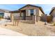 Alluring single-story home with a desert landscape in the front yard and a gated front porch at 1971 S 241St Dr, Buckeye, AZ 85326