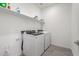 A clean laundry room featuring modern appliances and convenient shelving for storage at 1971 S 241St Dr, Buckeye, AZ 85326