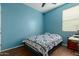 Blue bedroom features wood floors, a bed with a quilt, and a window at 21145 E Via De Olivos --, Queen Creek, AZ 85142