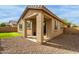 Exterior of home featuring a covered patio, rock landscaping and a small grassy area at 21145 E Via De Olivos --, Queen Creek, AZ 85142