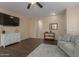 Cozy living room with dark wood floors, a modern console, comfortable seating, and a view into the hallway at 21145 E Via De Olivos --, Queen Creek, AZ 85142