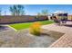 Well-maintained backyard features a manicured lawn, patio area, and desert landscaping at 2185 N Beverly Pl, Buckeye, AZ 85396