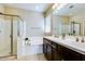 Bathroom featuring a soaking tub, walk-in shower, dual sinks, and tile flooring at 2185 N Beverly Pl, Buckeye, AZ 85396