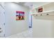 Hallway with cactus art, coat rack, tile flooring, and white paint at 2185 N Beverly Pl, Buckeye, AZ 85396